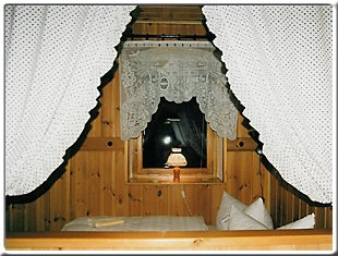 Gemütliches Kajütenbett mit Spitzengardinen